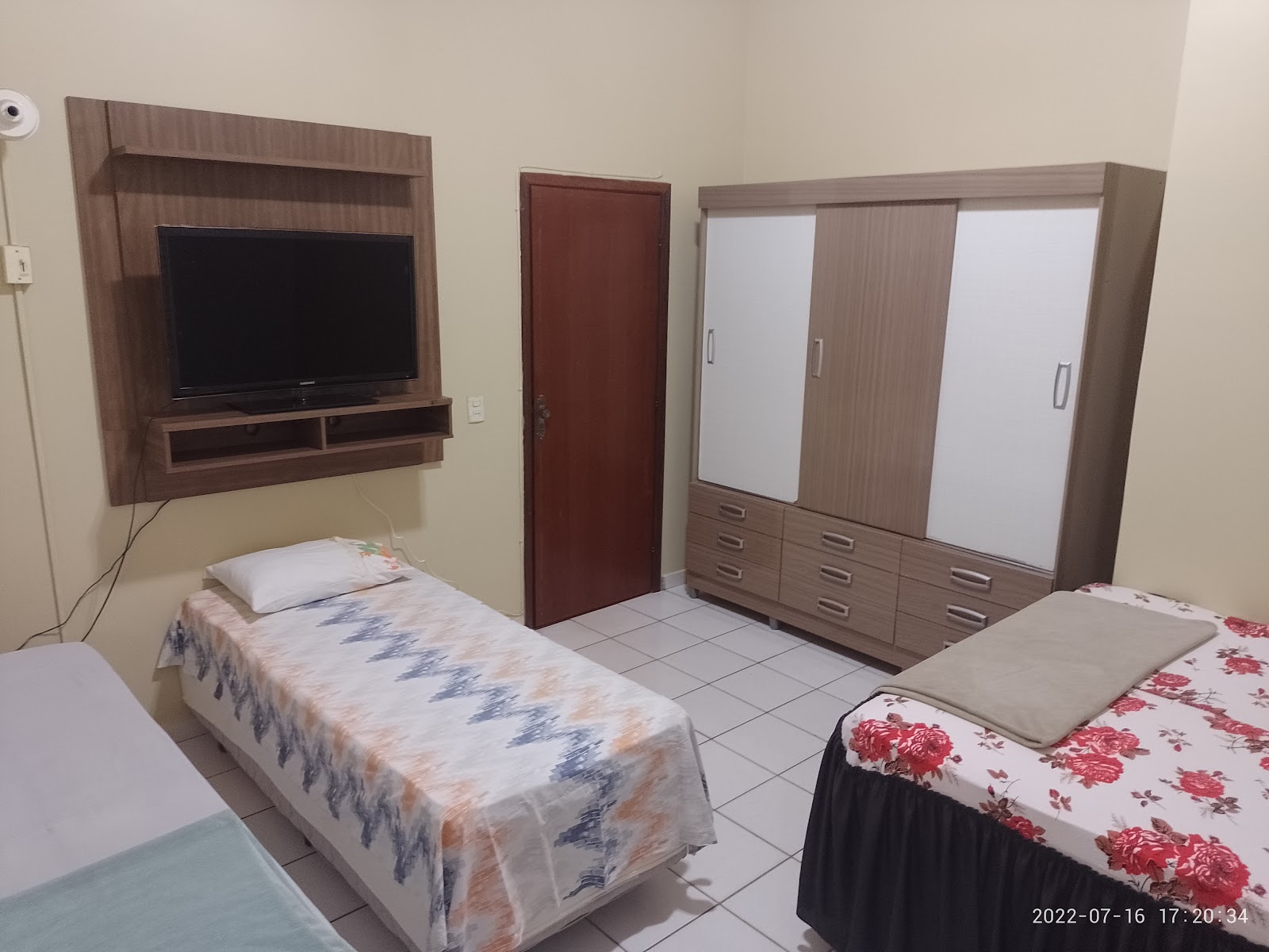 Suíte do Hotel Imperial — TV, guarda-roupa e duas camas